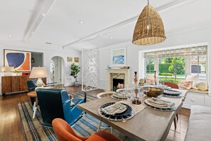A modern living room with a dining area, a fireplace, and a view of the outdoors. - Palm Beacher - Heated Salt Water Pool (Fort Lauderdale)