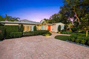 A two-story house with a brick driveway leading to a front door. - Palm Beacher - Heated Salt Water Pool (Fort Lauderdale)