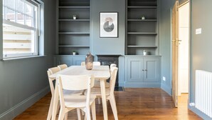 A dining area with a table and chairs, a fireplace, and built-in shelving.