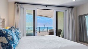 A hotel room with a large bed, a view of the ocean, and a balcony with a chair. - Oceanfront/Ground Floor Unit/A/C/Parking/Guest Favorite (La Jolla)