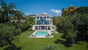 A large, two-story house with a swimming pool in the front yard.
