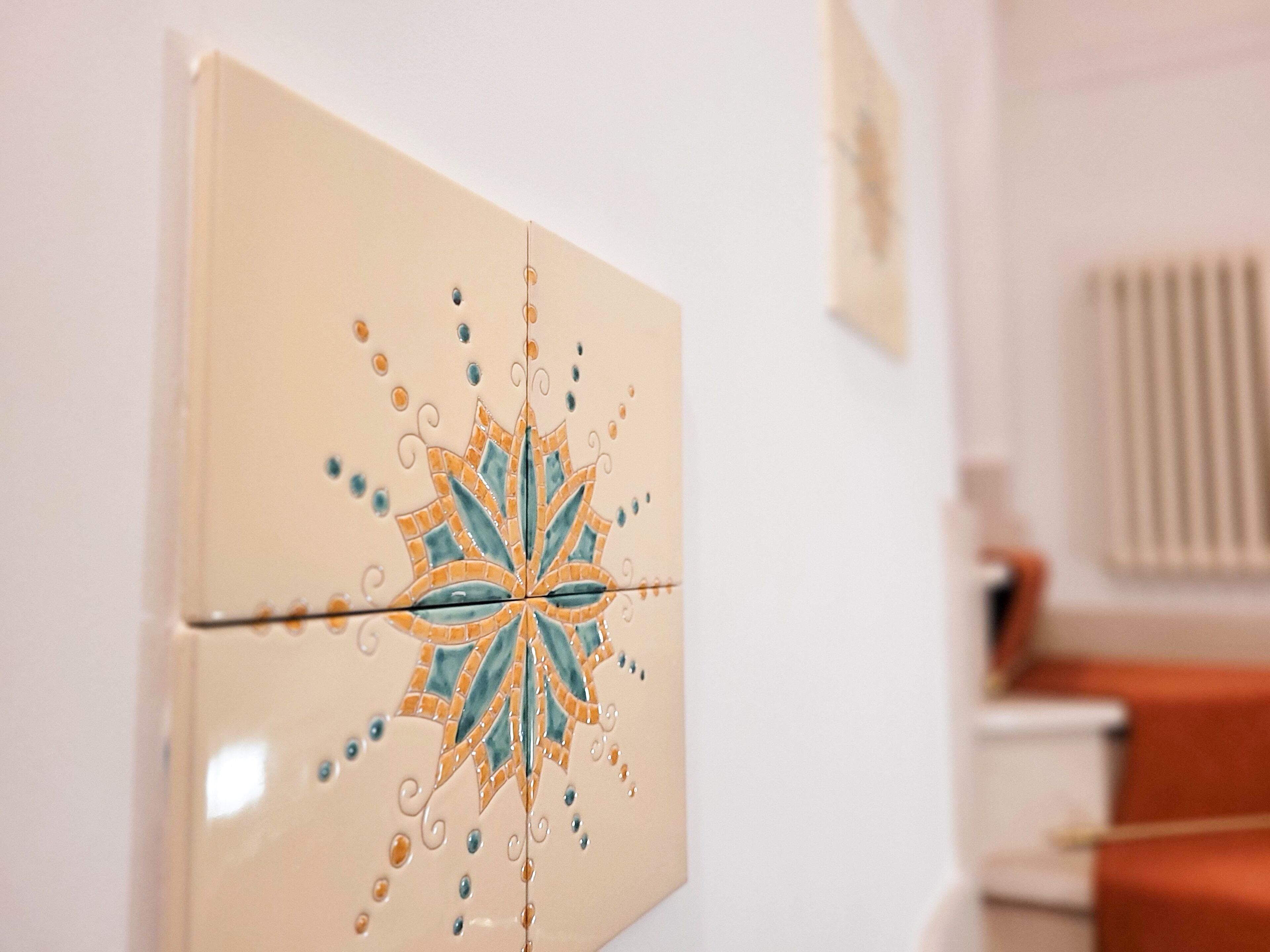 Una pared con un azulejo decorativo que presenta un diseño geométrico.