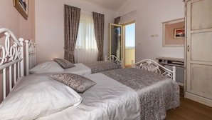 Una camera da letto con due letti, un armadio e una finestra con tende.