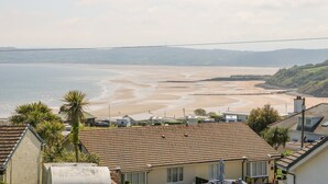 A coastal residential area with houses, a beach, and a view of the sea.