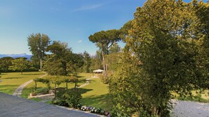 A landscaped garden with a gazebo, a pathway, and a view of distant mountains. - Villa The Park - Imperial Rome (Forte dei Marmi)