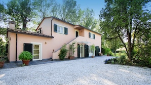 A two-story house with a gravel driveway, a front porch, and potted plants. - Villa The Park - Imperial Rome (Forte dei Marmi)