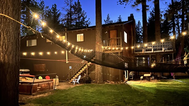 Ein Haus mit Terrasse, einer Hängematte und Lichterketten.