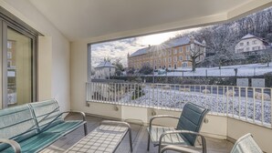 A balcony with a view of a snow-covered landscape and buildings. - View Point Semnoz 4* - OG IMMO (Annecy)