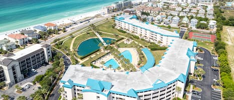 Ein Resort mit einem zentralen Pool, mehreren Gebäuden und Blick auf den Strand.
