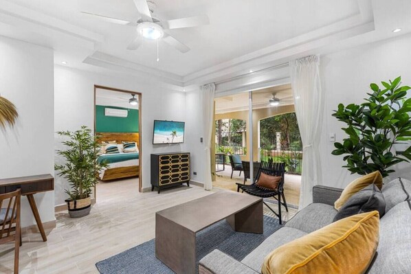 Un salón moderno con sofá, mesa de centro y cama con vistas a un balcón.