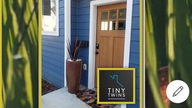 A house with blue siding, a wooden front door, and a potted plant near the entrance. - Downtown Stay at the Blue Tiny Twin (Roseburg)