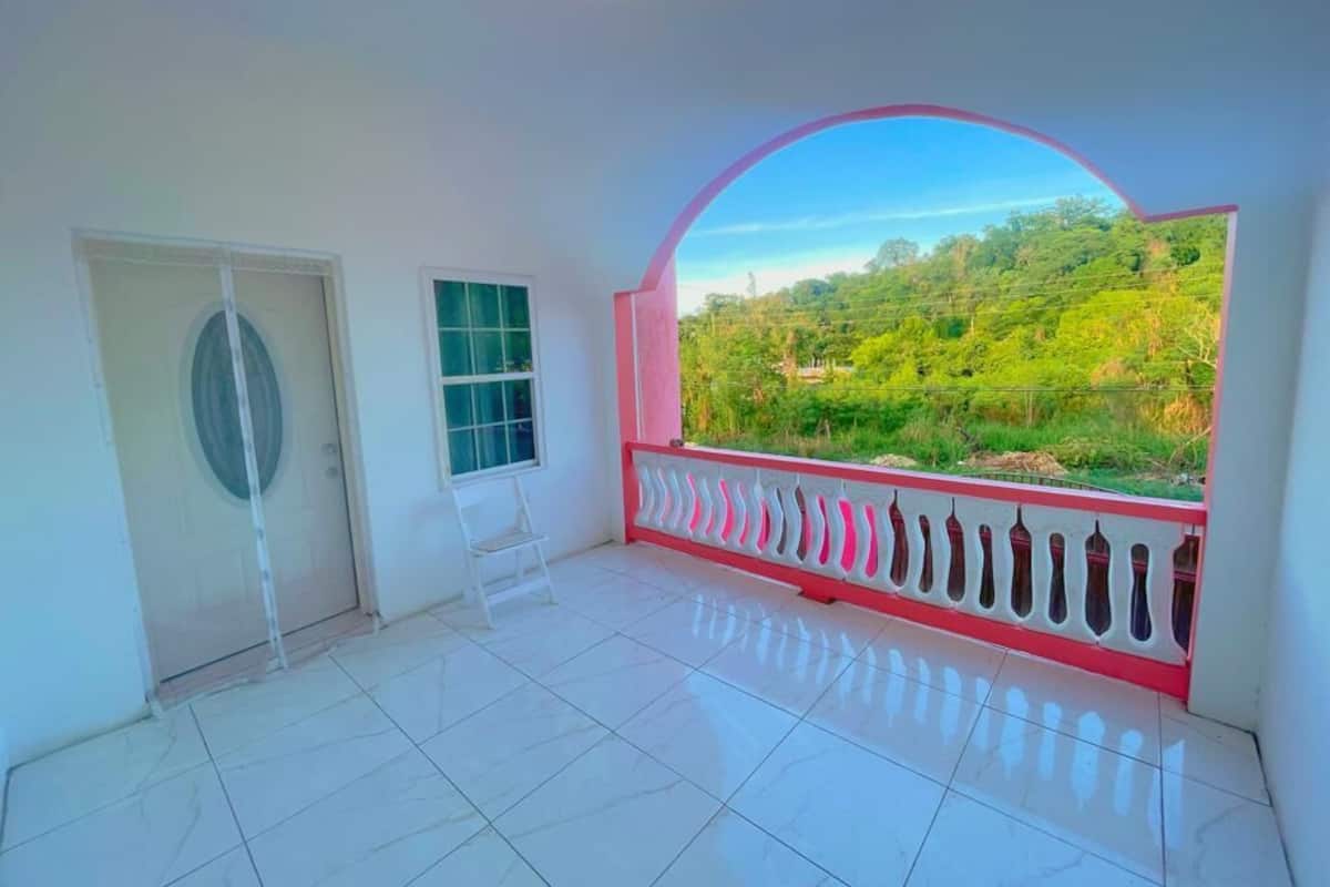 A room with a balcony, a door, and a window.