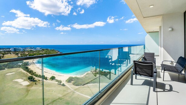 A balcony with a clear view of a beach and ocean. - 1902- Stunning sub-penthouse oceanview (Cupecoy)