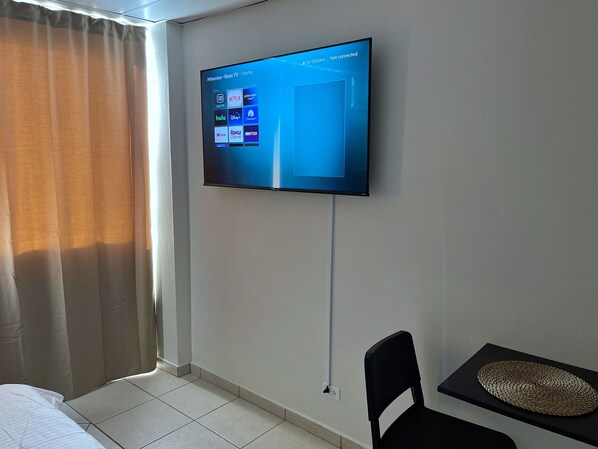 A hotel room with a flat-screen TV mounted on the wall displaying streaming services. - Relaxing Isla Verde Studio • Walk to Beach • Pool (Carolina)