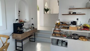 A modern kitchen with a coffee station, breakfast bar, and various food items. - PAROS FIVE SENSES (Paros)