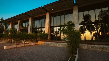 A modern building with large windows and a gravel courtyard.