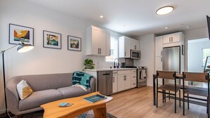 A modern apartment with a living room, kitchenette, and dining area. - Modern Seattle Townhome Near Downtown & Parks (Seattle)