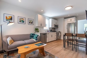 A modern apartment with a living room, kitchenette, and dining area. - Modern Seattle Townhome Near Downtown & Parks (Seattle)