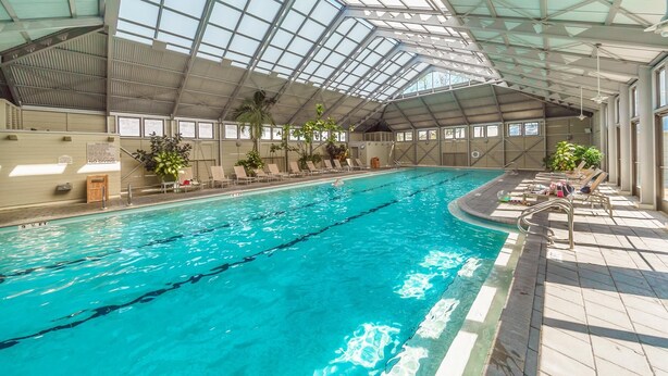 An indoor swimming pool with clear water, surrounded by lounge chairs and potted plants. - AVAILABLE SHORTLY/PRIVATE BEACH-Mediterranean Ambiance-Open Living-4 Bikes (Rosemary Beach)
