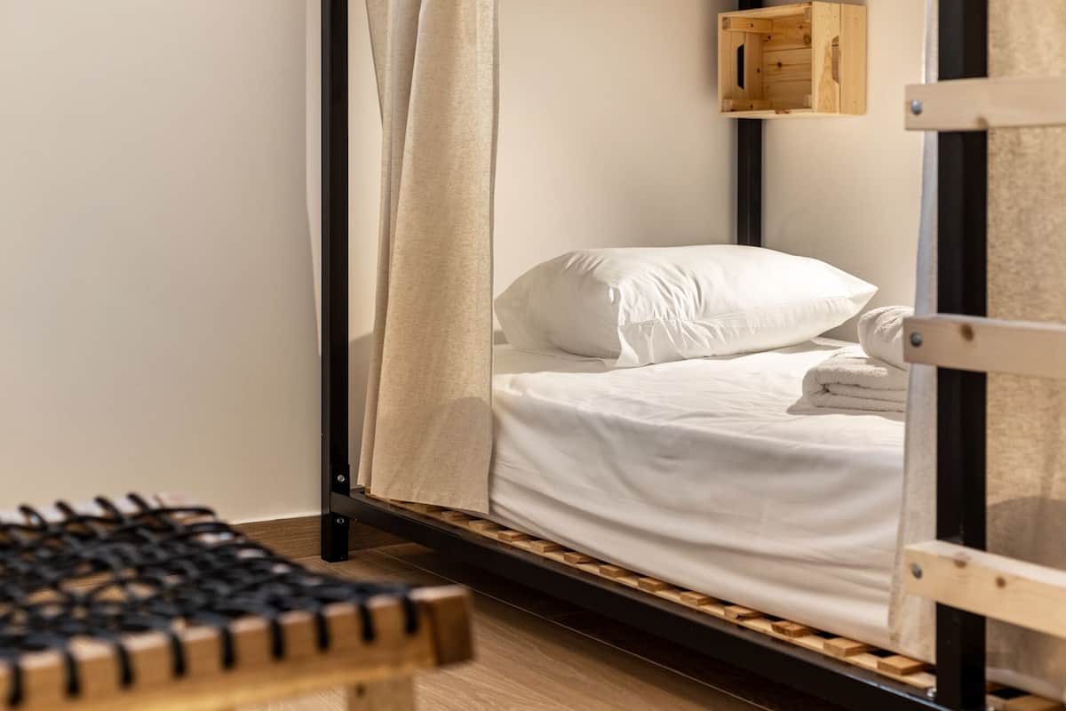 A bed with a wooden frame, white bedding, and a wooden headboard.