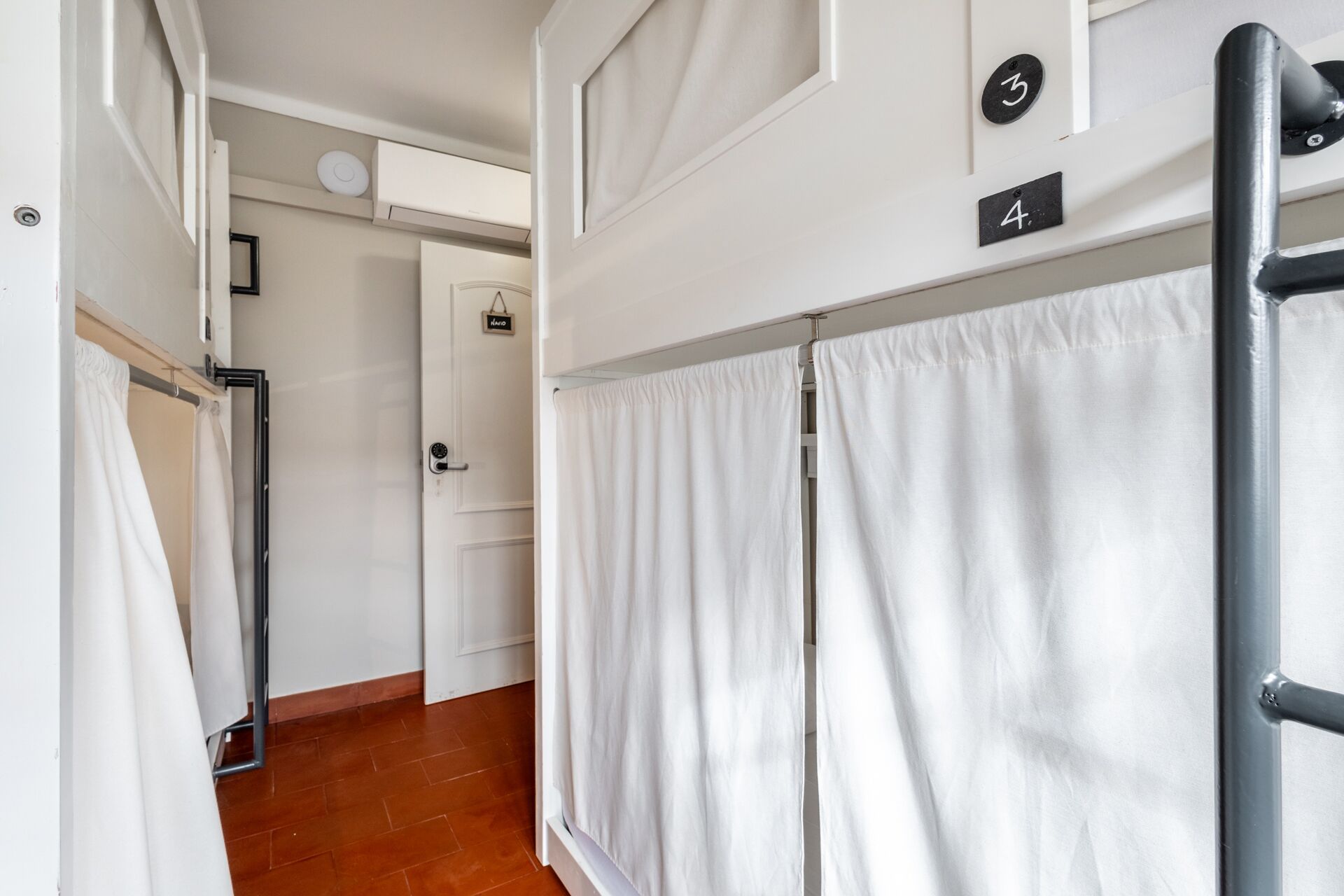 A corridor with white curtains, a door with a 'No Entry' sign, and a number '4' sign.