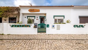 Un bâtiment blanc avec une enseigne indiquant « SANTA SEA & SUN » et un portail vert.