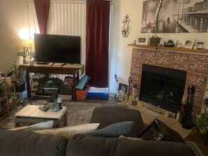 Relax in this inviting living room with a flat-screen TV, comfortable sofa, and cozy fireplace.