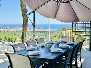 A dining table set outdoors with a view of the sea and cityscape. - Cardina CostaBravaSi - Pool, A/C, barbecue, views (Sant Feliu de Guíxols)