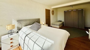 A bedroom with a bed, bedside table, lamp, and a small seating area with a chair and a bench. - Cardina CostaBravaSi - Pool, A/C, barbecue, views (Sant Feliu de Guíxols)