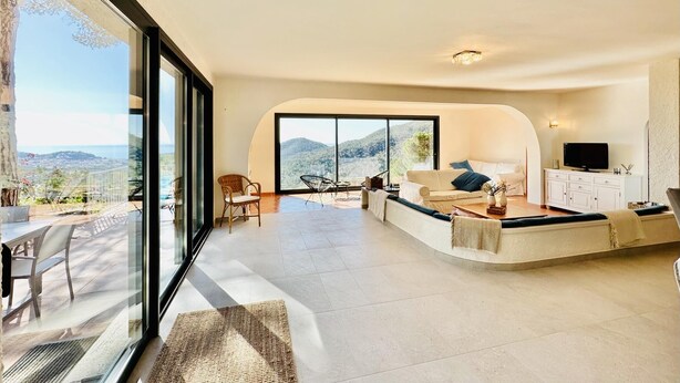 A spacious living area with a large sliding glass door leading to a balcony, a sofa set, a coffee table, and a TV on a cabinet. - Cardina CostaBravaSi - Pool, A/C, barbecue, views (Sant Feliu de Guíxols)