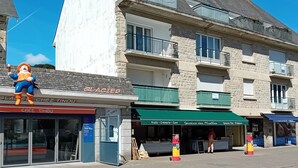 A street view with a building featuring a stone facade, a blue awning, and a sign reading "Glacier".