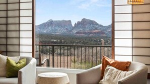 Un balcón con vista a montañas, un sofá y una pequeña mesa.