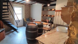 Un interior rústico con una escalera de caracol, barriles de madera y una pared de piedra.