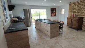 Una cocina moderna con una isla central, armarios de madera y una pared de acento de piedra.