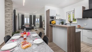 Un appartamento moderno con angolo ristoro, cucina e zona giorno.