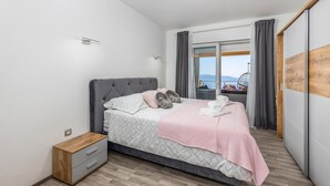 Una camera da letto con un letto, un comodino, un armadio e vista mare.