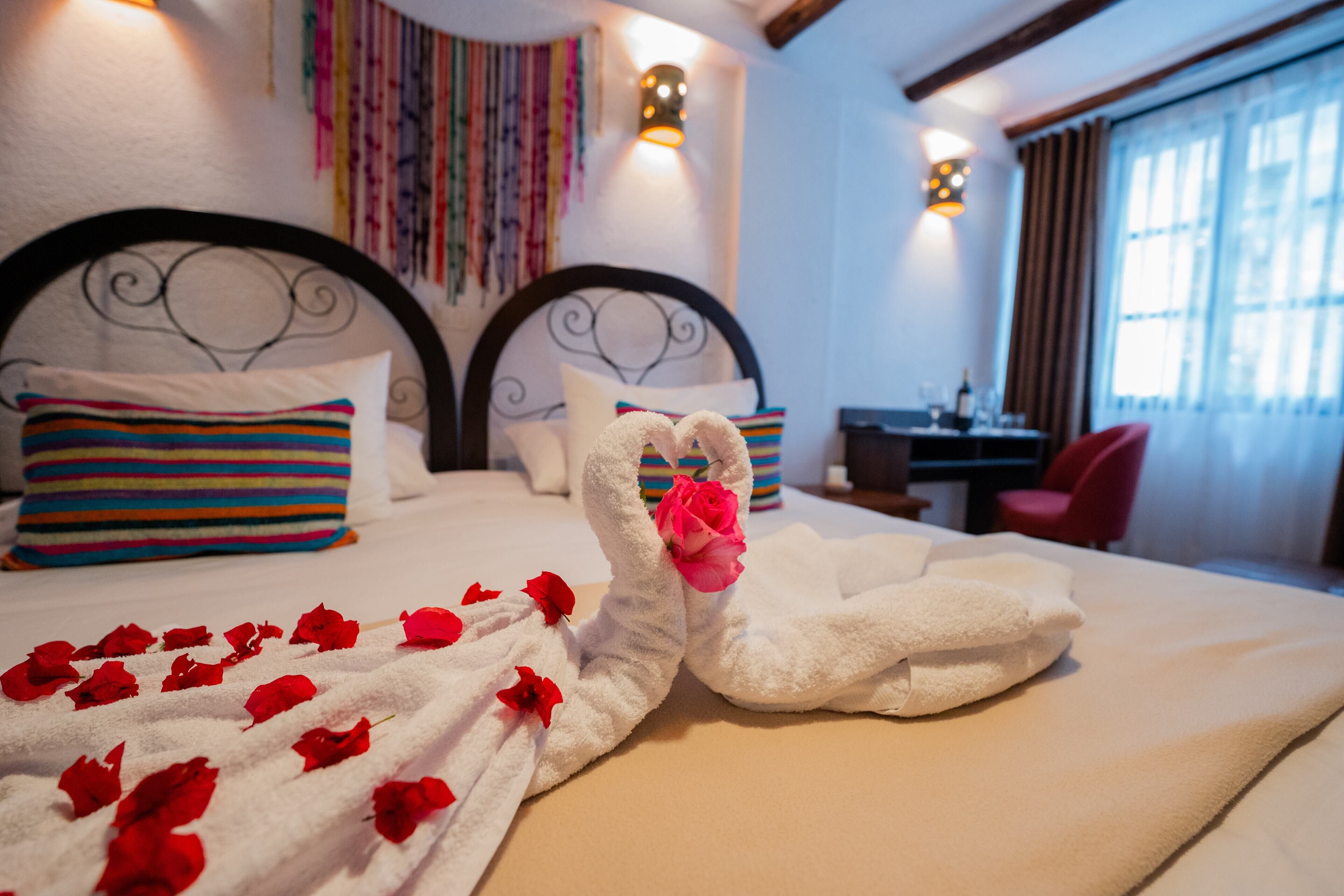Quarto de hotel com cama, almofadas, escrivaninha e cadeira.