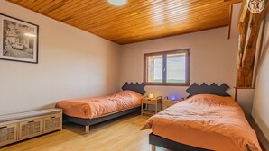 Ein Schlafzimmer mit zwei Betten, einem Schreibtisch und einem Fenster.