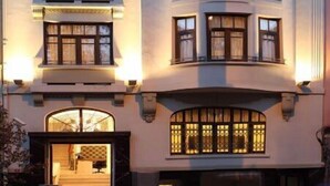 A multi-story building with a symmetrical facade, large windows, and a central entrance with a glass door. - Atik Suite Taksim  (Istanbul)