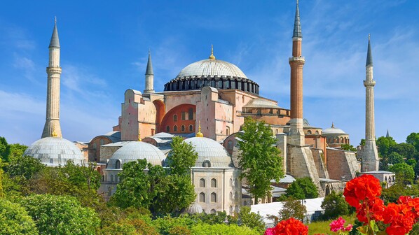A historic building with multiple domes and minarets, surrounded by lush greenery and vibrant flowers. - Atik Suite Taksim  (Istanbul)