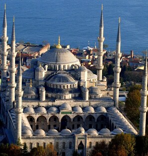 A large mosque with multiple domes and minarets, surrounded by a cityscape and a body of water. - Atik Suite Taksim  (Istanbul)