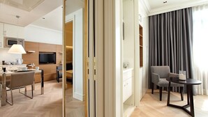 A modern hotel room with a dining area, a TV, a sofa, and a large window with curtains. - Atik Suite Taksim  (Istanbul)
