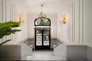A grand entrance with a black gate, white walls, and a chandelier. - Atik Suite Taksim  (Istanbul)
