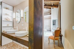 A bathroom with two sinks, a mirror, and a shelf with decorative items. - BMGA | Luxury Home with Patio in Trastevere (Roma)