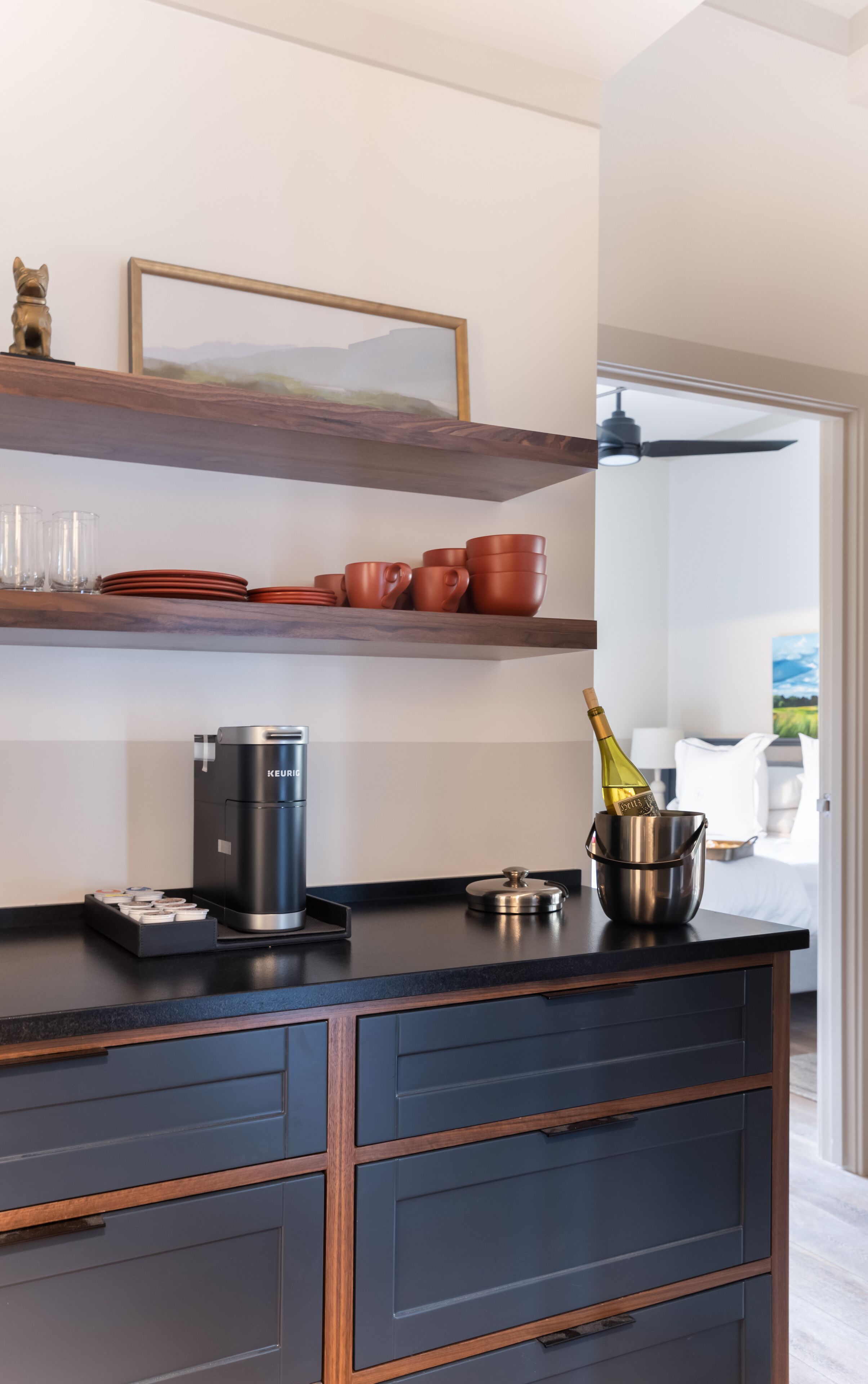 Una cocina moderna con una cafetera, una botella de champán y una estatua decorativa de un perro.