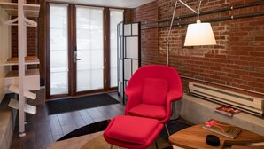 A modern living room with a red chair, a wooden coffee table, and a hanging lamp. - Queen Anne Design Studio, 7days max. (Seattle)