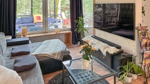 A modern living room with a glass coffee table, a sofa, and a fireplace.