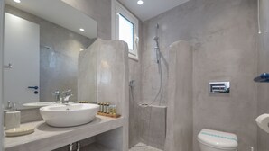 Ein modernes Badezimmer mit einem großen Waschbecken, einer Toilette und einer Duschkabine.