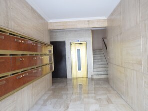 Stylish hallway with secure storage, a door to upper levels, and a staircase for easy access.