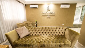 Un sofá lujoso y acolchado en el vestíbulo de un hotel, con un letrero que dice "Porty Brasil Hotel".